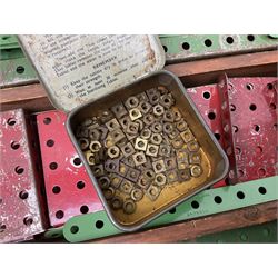 Meccano - large quantity of loose parts including various plates and strips, flanged plates, pulleys, axle rods and crank handles, wheels and tyres, gear wheels, brackets, nuts & bolts, various manuals; predominantly red and green; some in compartmentalised wooden trays