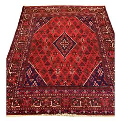 Central Persian Josheghan red ground carpet, central lozenge within field decorated with repeating floral lozenges, the border bands decorated with geometric designs