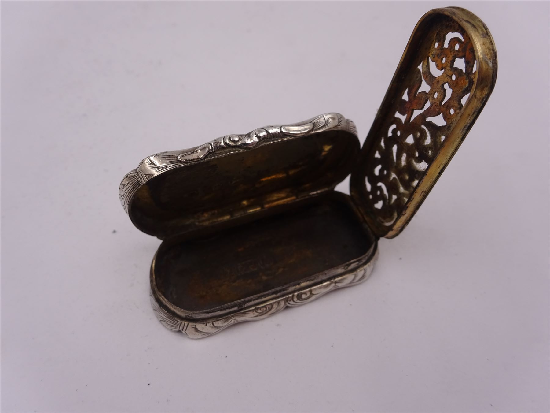 Victorian silver vinaigrette, of oval form with shaped rim, with engraved scrolling and foliate decoration and cartouche with initials, with foliate pierced gilt interior, hallmarked David Pettifer, Birmingham 1855, L4.3cm