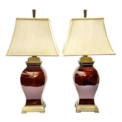 Pair of sang de boeuf style table lamps, of baluster form with brass effect mounts, with gold silk rectangular shaped shades, lamp base H51.5cm