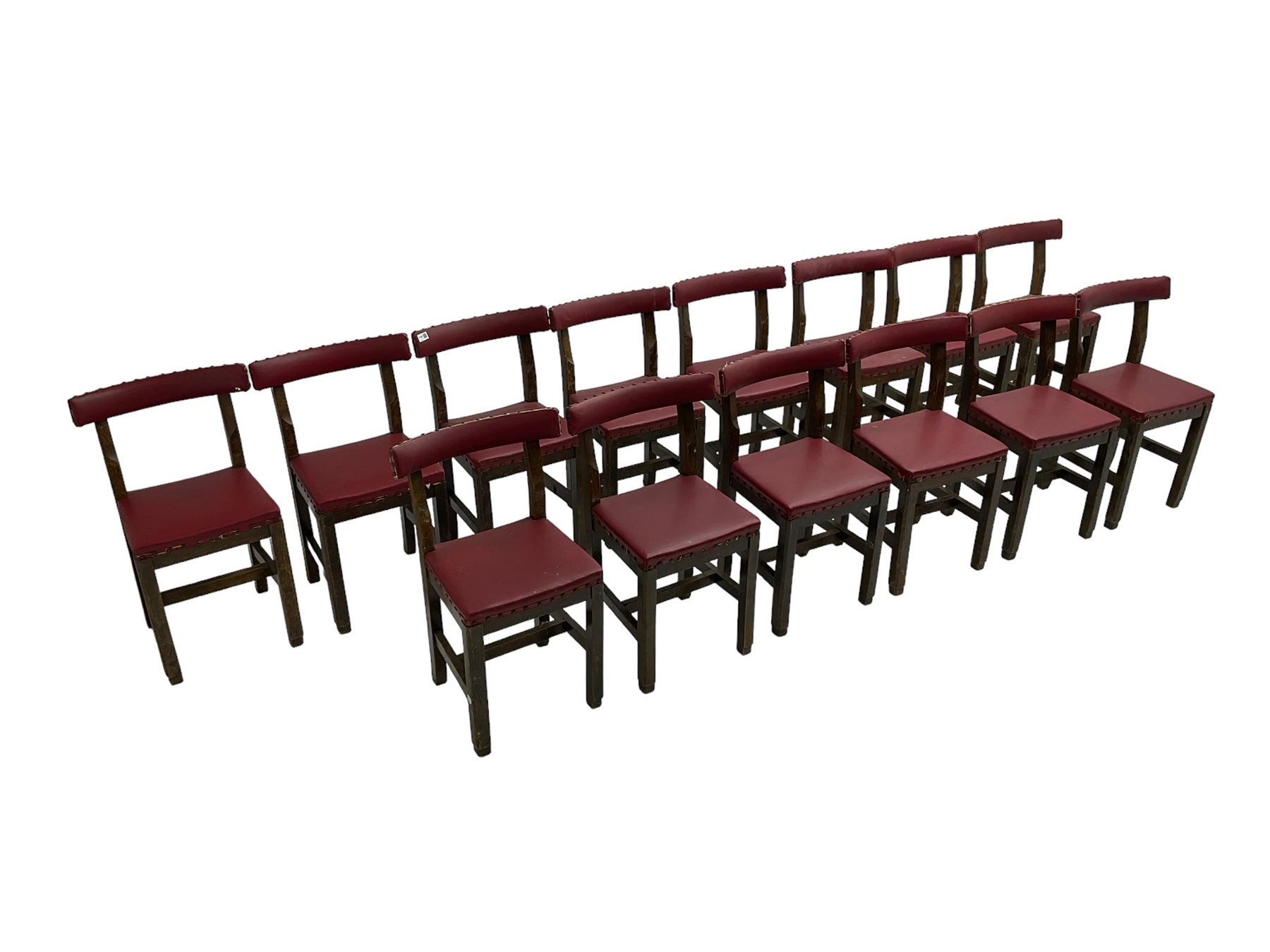 Set fifteen early 20th century oak school chairs, back rail and seat upholstered in claret red faux leather with studwork, raised on square supports united by H-stretcher (15)