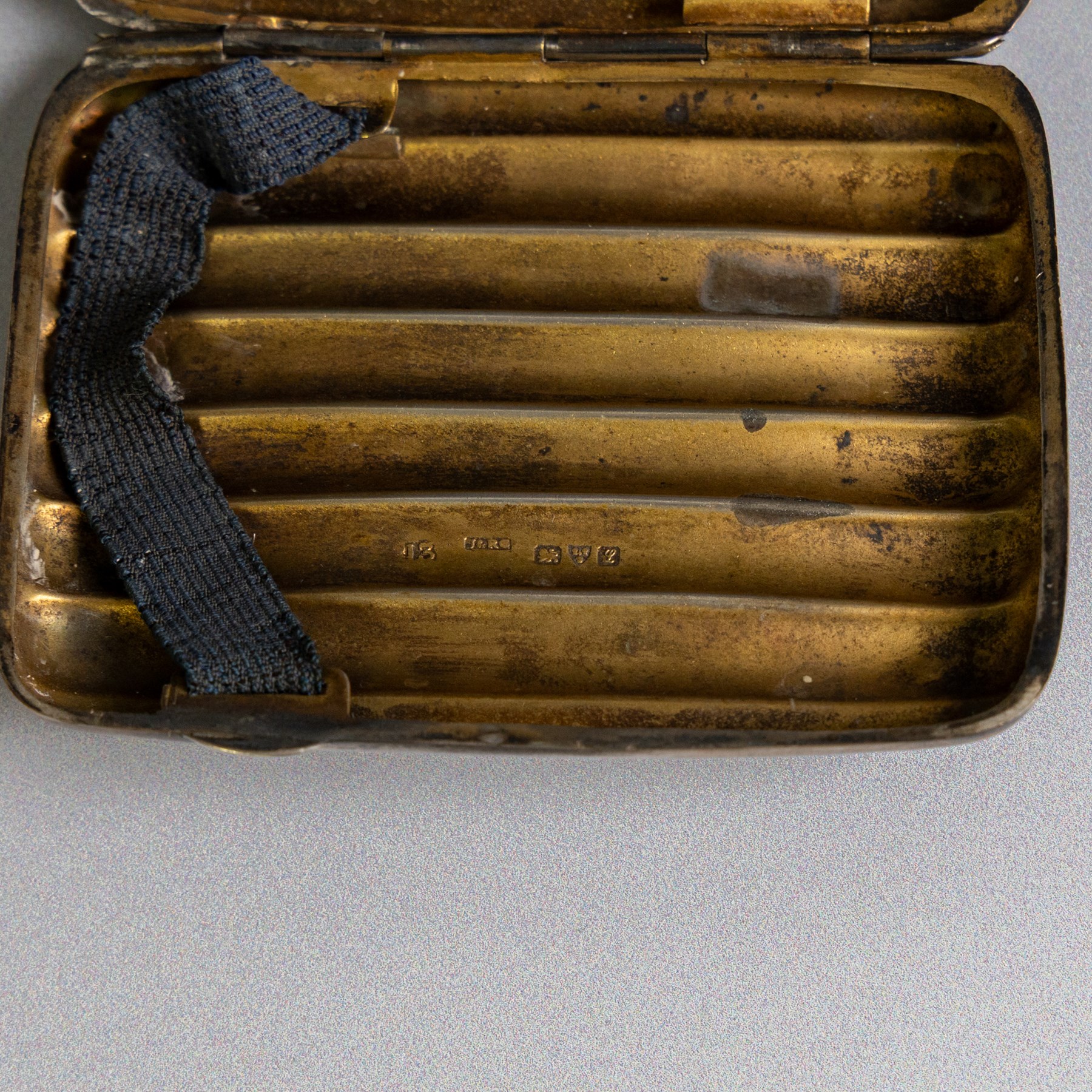 Two early 20th century silver cigarette cases, comprising a rectangular example with foliate decoration and vacant shield cartouche and a 1920s example with engine turned decoration and engraved initials, both hallmarked