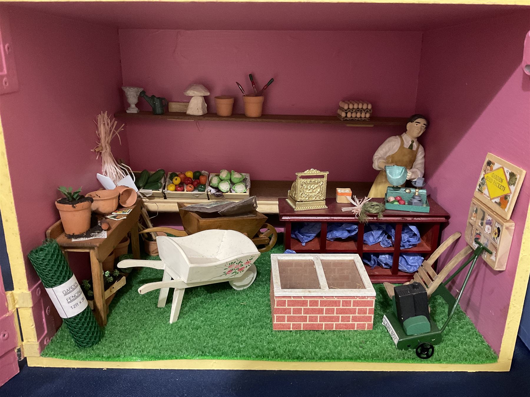 Three scratch-built wooden shop dioramas - single room Pet Shop with hinged front, fully furnished and well stocked with animals, birds and numerous accessories; and matching Garden Shop, fully furnished and well stocked with fruit, vegetables and garden accessories including lawn mower, wheelbarrows etc; each W34cm H27cm D26cm; and double fronted single room Butchers Shop with butcher at his block, partially stocked counter and two delivery cycles W57cm (3)