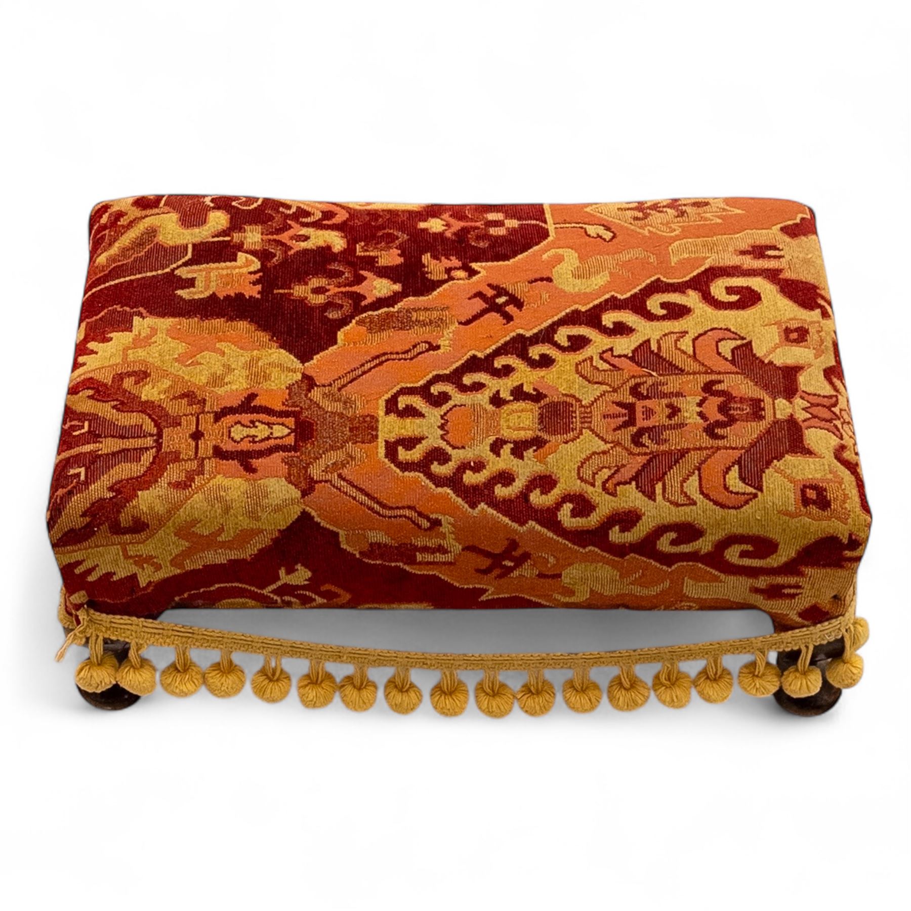 20th century Georgian style upholstered wingback armchair with footstool, the chair in yellow and red plaid fabric, the stool with fringed tapestry cover