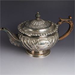 Victorian silver four piece tea service, comprising hot water pot, teapot, milk jug and sugar bowl, of circular part fluted bellied form, with embossed and engraved floral decoration, engraved with initials to body, the teapot and hot water pot with wooden handles and finials, hallmarked Z Barraclough & Sons, Sheffield 1898