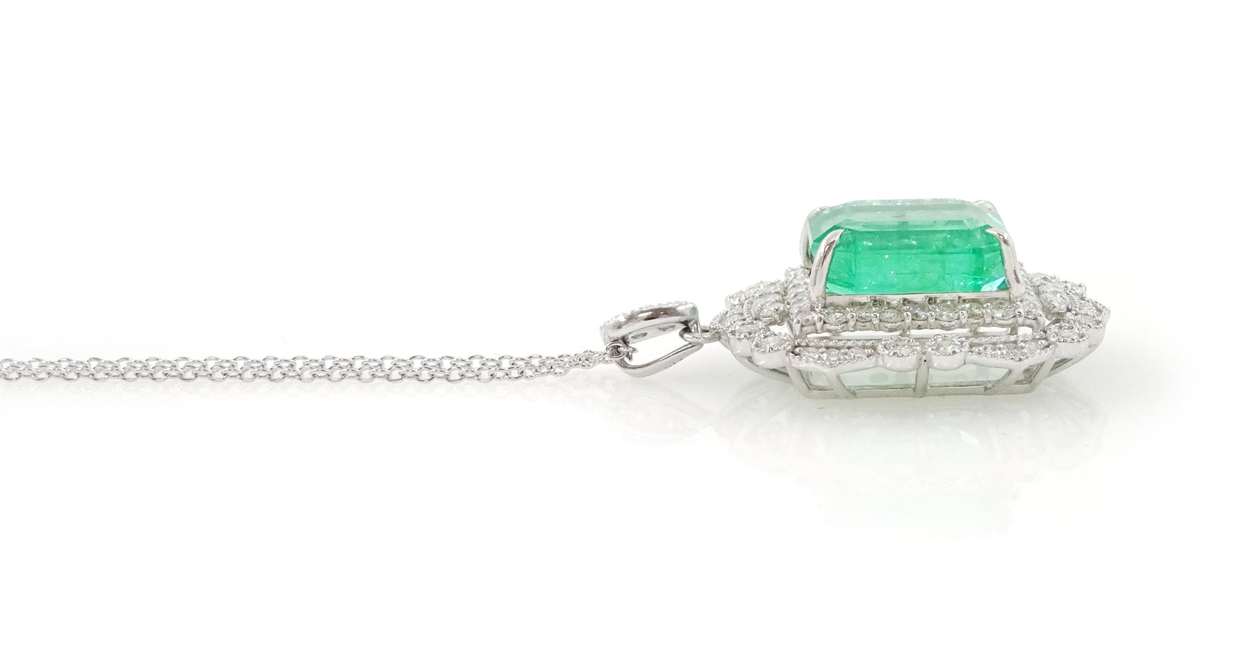 Platinum Colombian emerald and diamond pendant necklace, single octagonal cut emerald of 7.38 carat, surrounded by round cut diamonds in a fancy milgrain pierced design setting, stamped Pt 950, on a trace link chain necklace, total diamond weight 1.14 carat, with GCS certificate