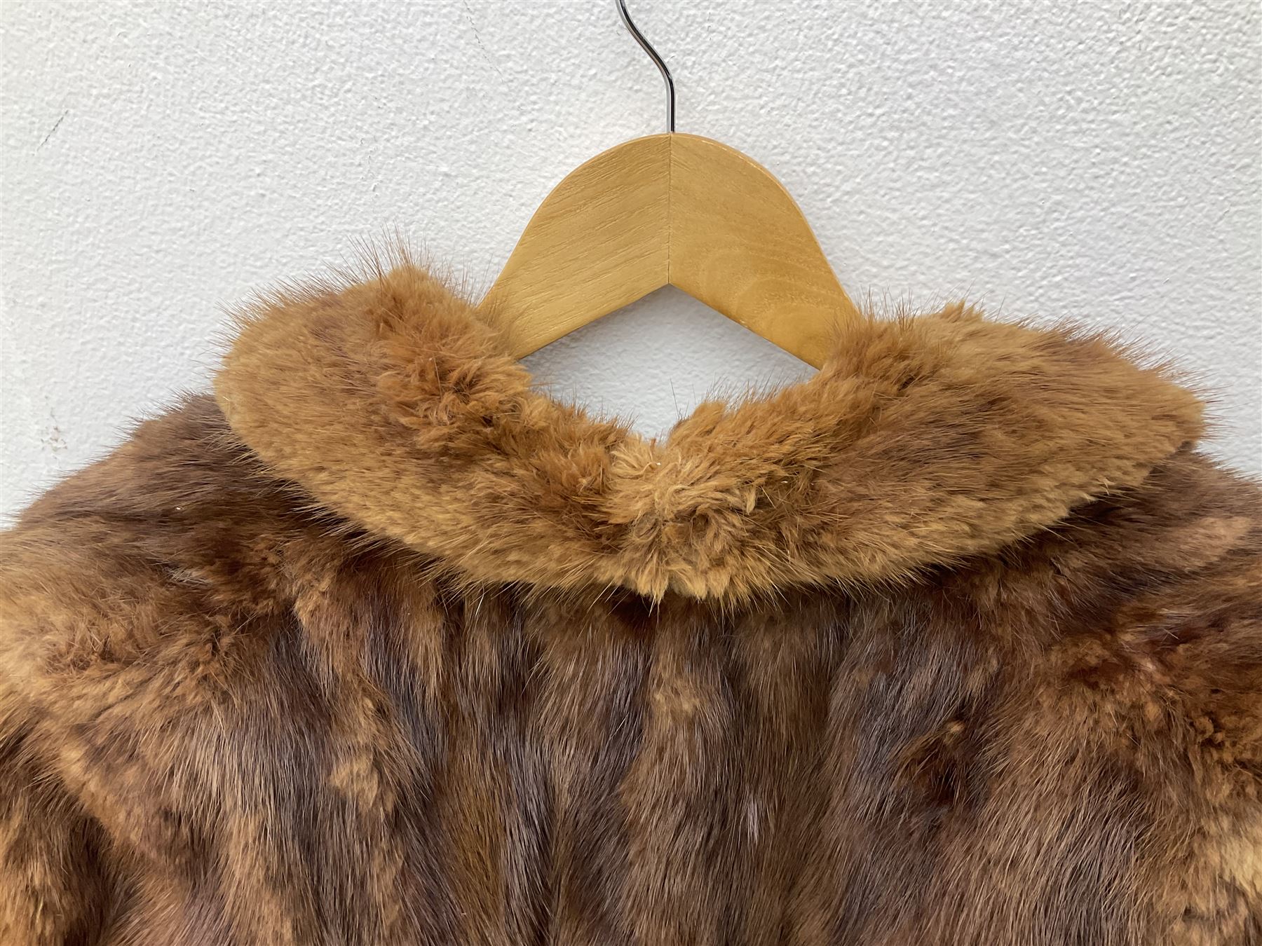 Brown mid length musquash fur coat by National Fur Company together with white rabbit cape
