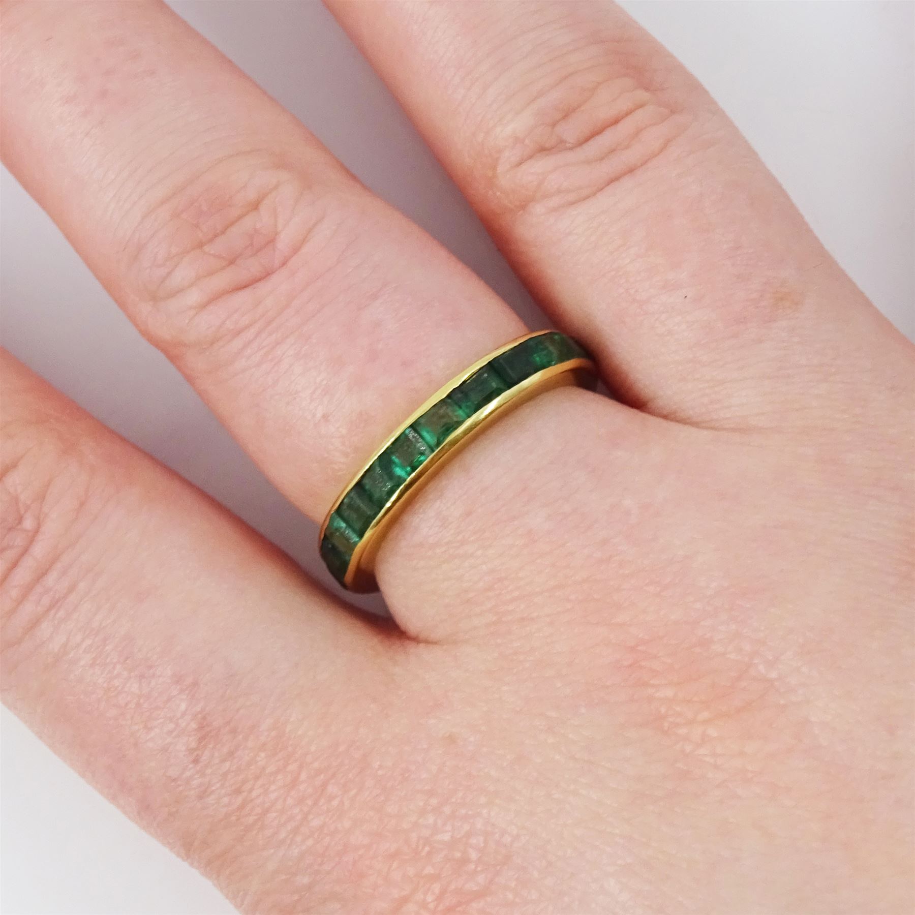 18ct gold emerald full eternity ring, channel set with calibre cut emeralds