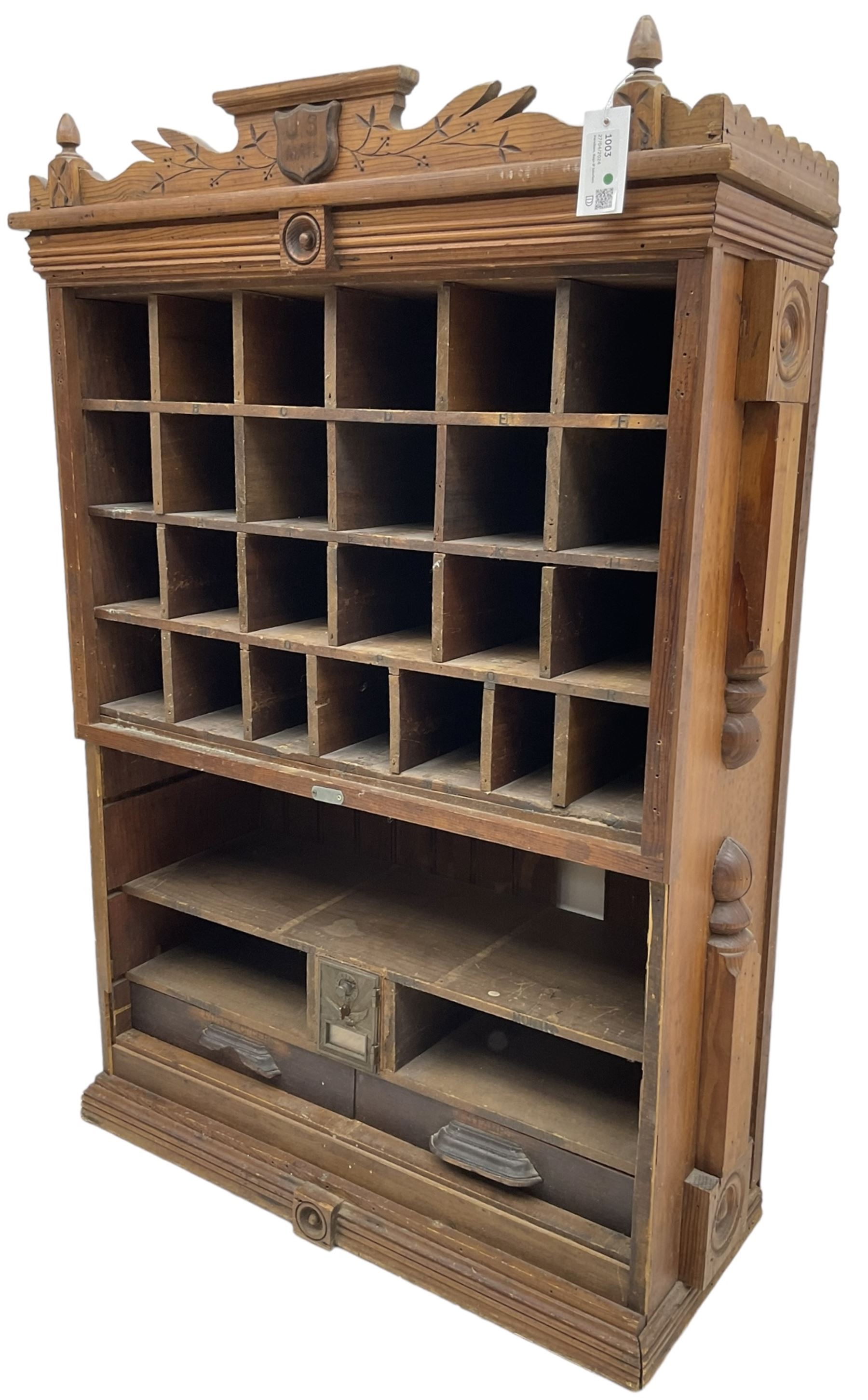 19th century stained pitch pine 'US Mail' pigeonhole unit, raised carved gallery with applied inscribed shield plaque, fitted with twenty five pigeon holes over shelves and correspondence drawers