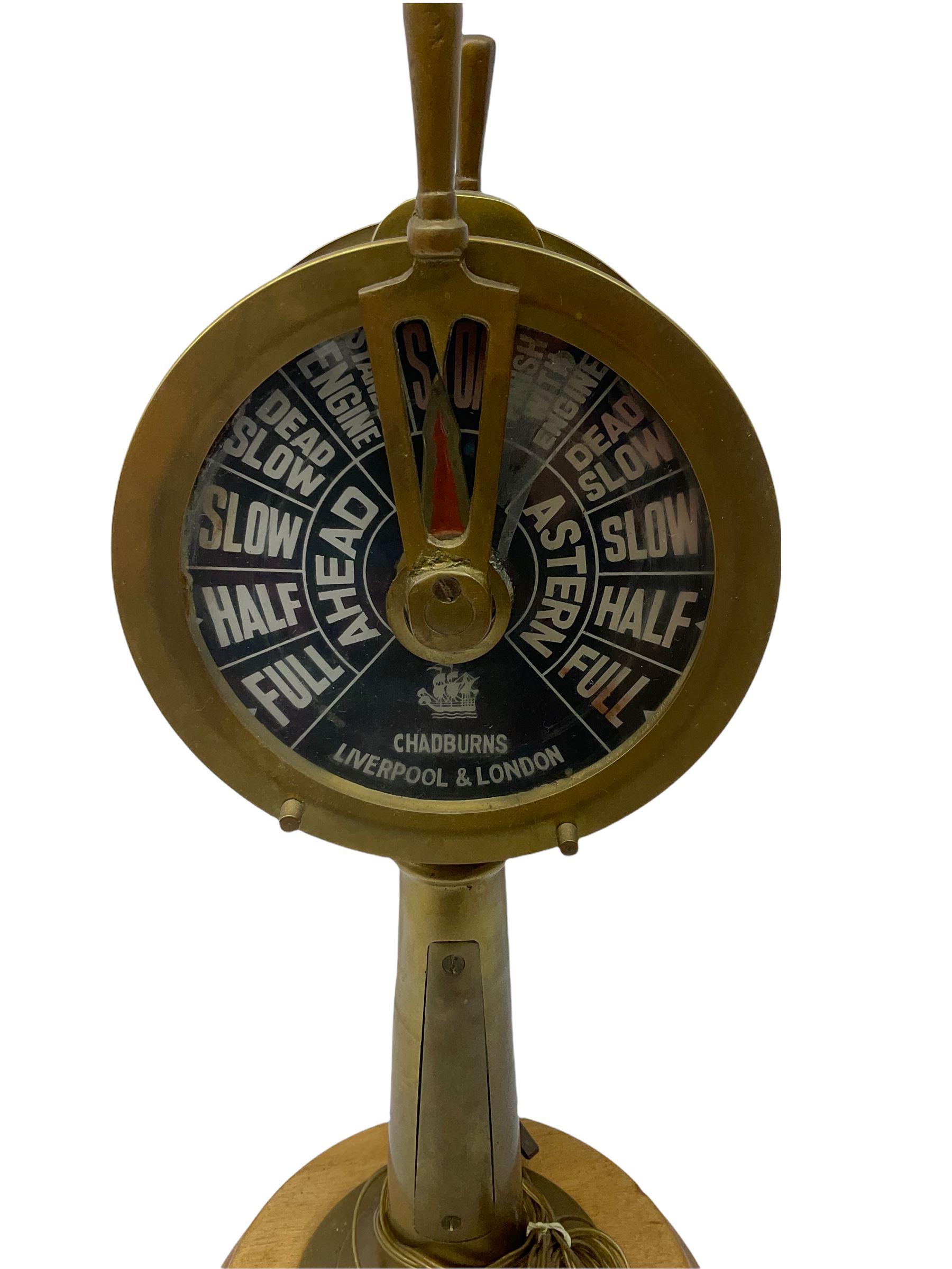 Early 20th century, illuminating brass ship's telegraph by Chadburns of Liverpool and London, on a circular wooden plinth, H55cm