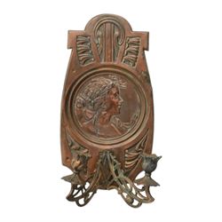 Pair of late 19th/early 20th century Art Nouveau copper twin branch wall sconces, each with shaped back plate chased with a central panel of a maiden in profile above and surmounted by foliate motifs, supporting two foliate open cast branches with bud sockets above conforming drip pans, H31cm W16cm D8.5cm
