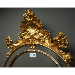  Ornate mirror in gilt cushion frame, shell and floral pediment, 63cm x 115cm  