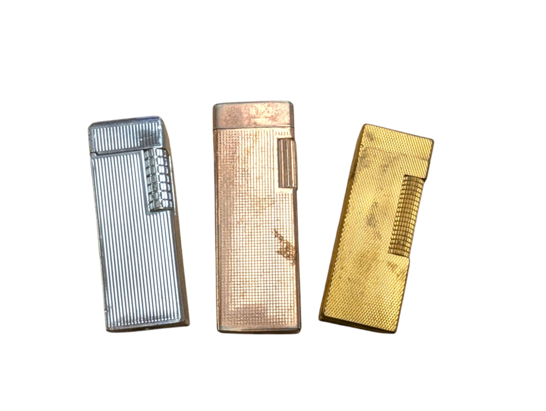 Dunhill gold plated lighter with engine turned decoration, with two other lighters