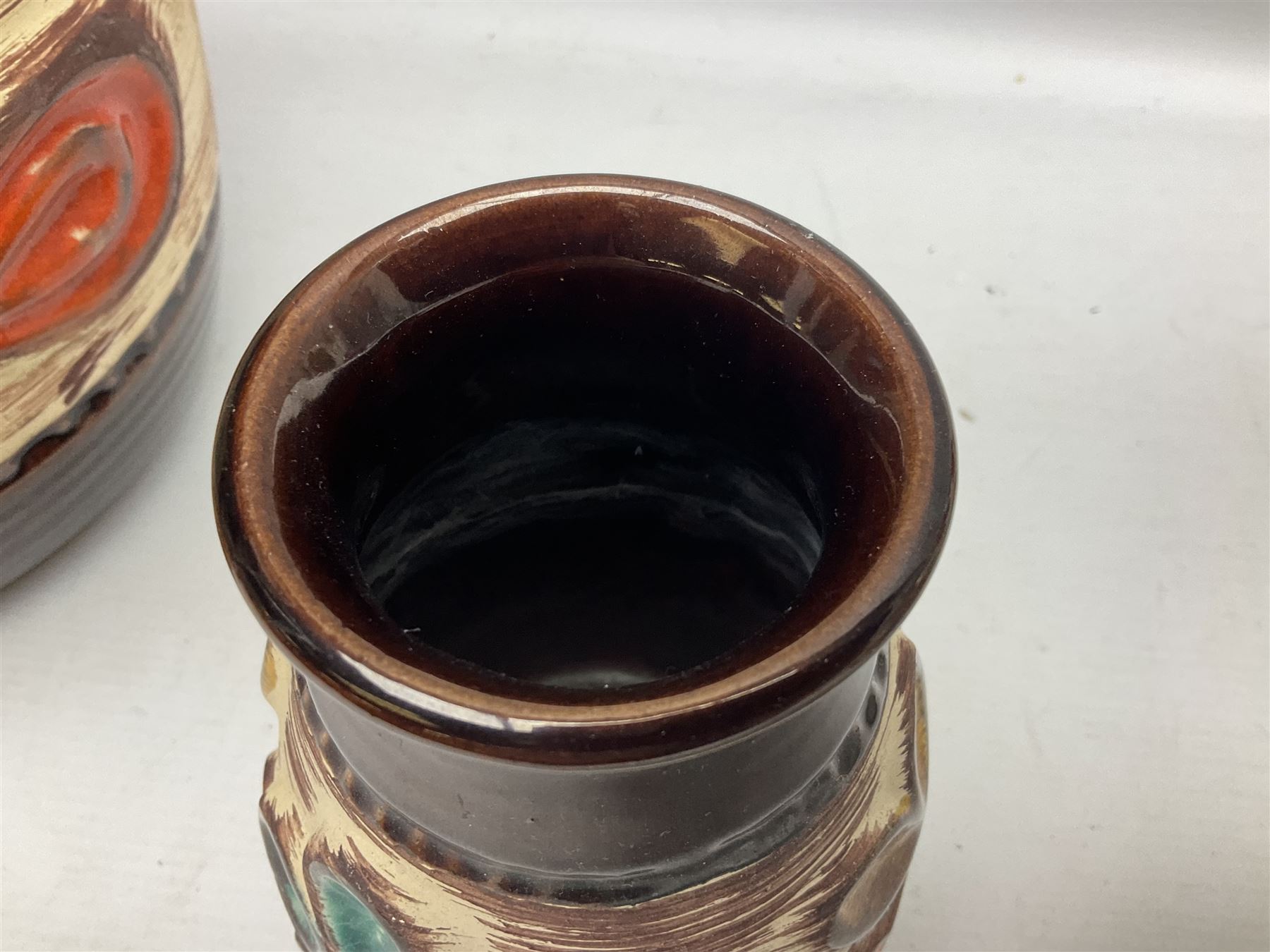 Pair of Bay West German vases, with bold moulded flower and foliage decoration in green, orange and ochre on brown ground, largest H40cm