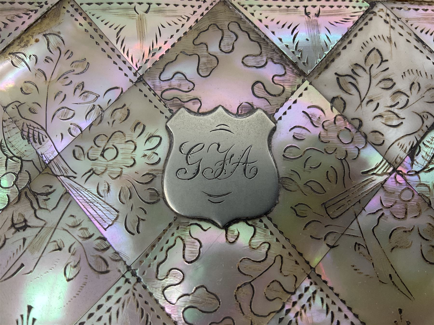 Victorian mother of pearl tea caddy, of rectangular bow-fronted form, the body with floral, bird and geometric engraved mother of pearl panels, white metal shield plaque to the cover inscribed with the initials G.J.A and similar escutcheon, the two division interior with ivory edging and two panelled mother of pearl lids, on four vegetable ivory bun feet L20cm, together with a similar style mother of pearl card case (2) This item has been registered for sale under Section 10 of the APHA Ivory Act