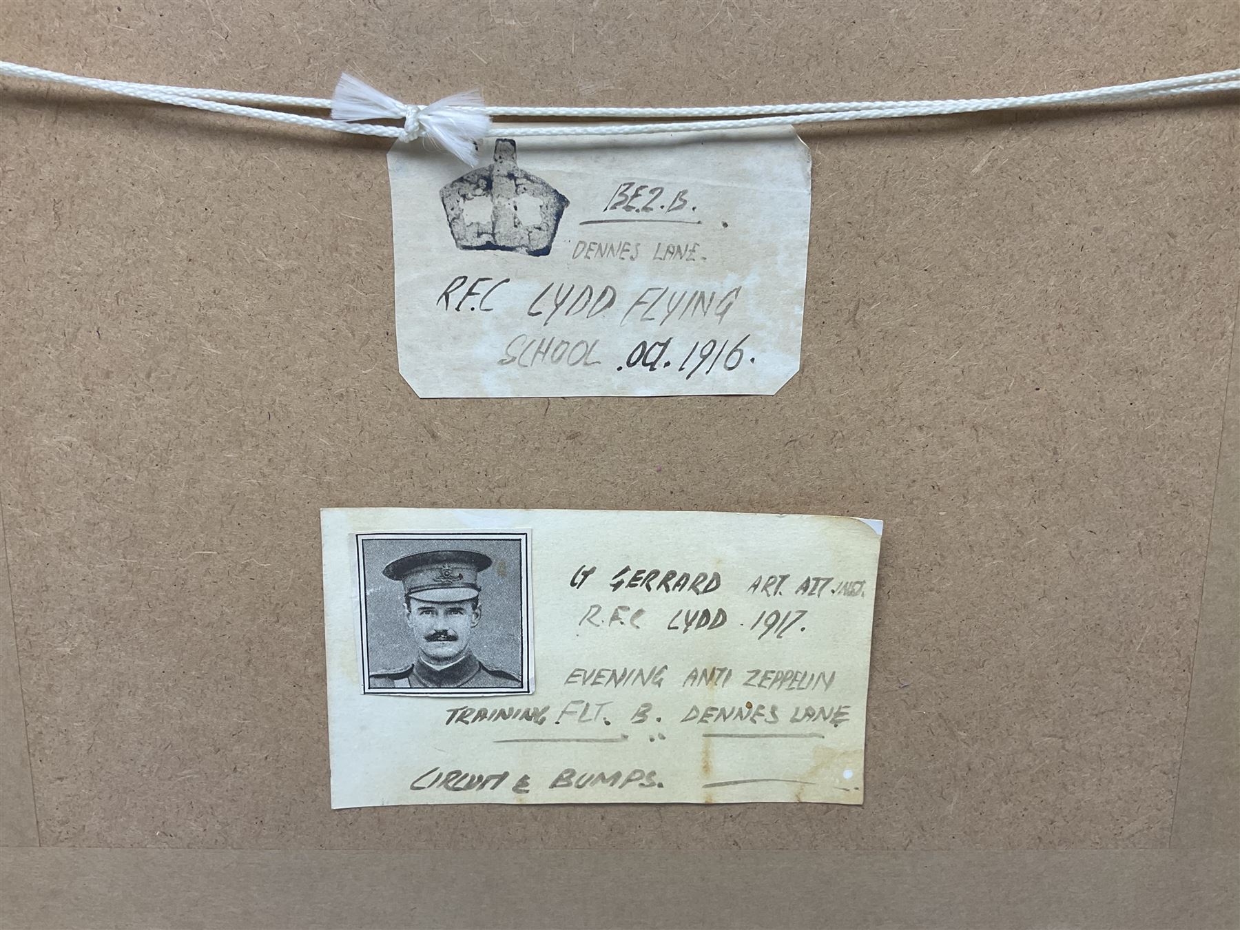T. Page (early 20th century) - RFC bi-plane in flight over an airfield, bears labels verso 'BE2.B. Dennes Lane R.F.C. Lydd Flying School Oct.1916' and 'Lt. Gerrard R.F.C Lydd 1917 Evening Anti Zeppelin Training Flt. B. Dennes Lane Circum & Bumps', signed watercolour 20.5 x 22.5cm, later mahogany stained frame