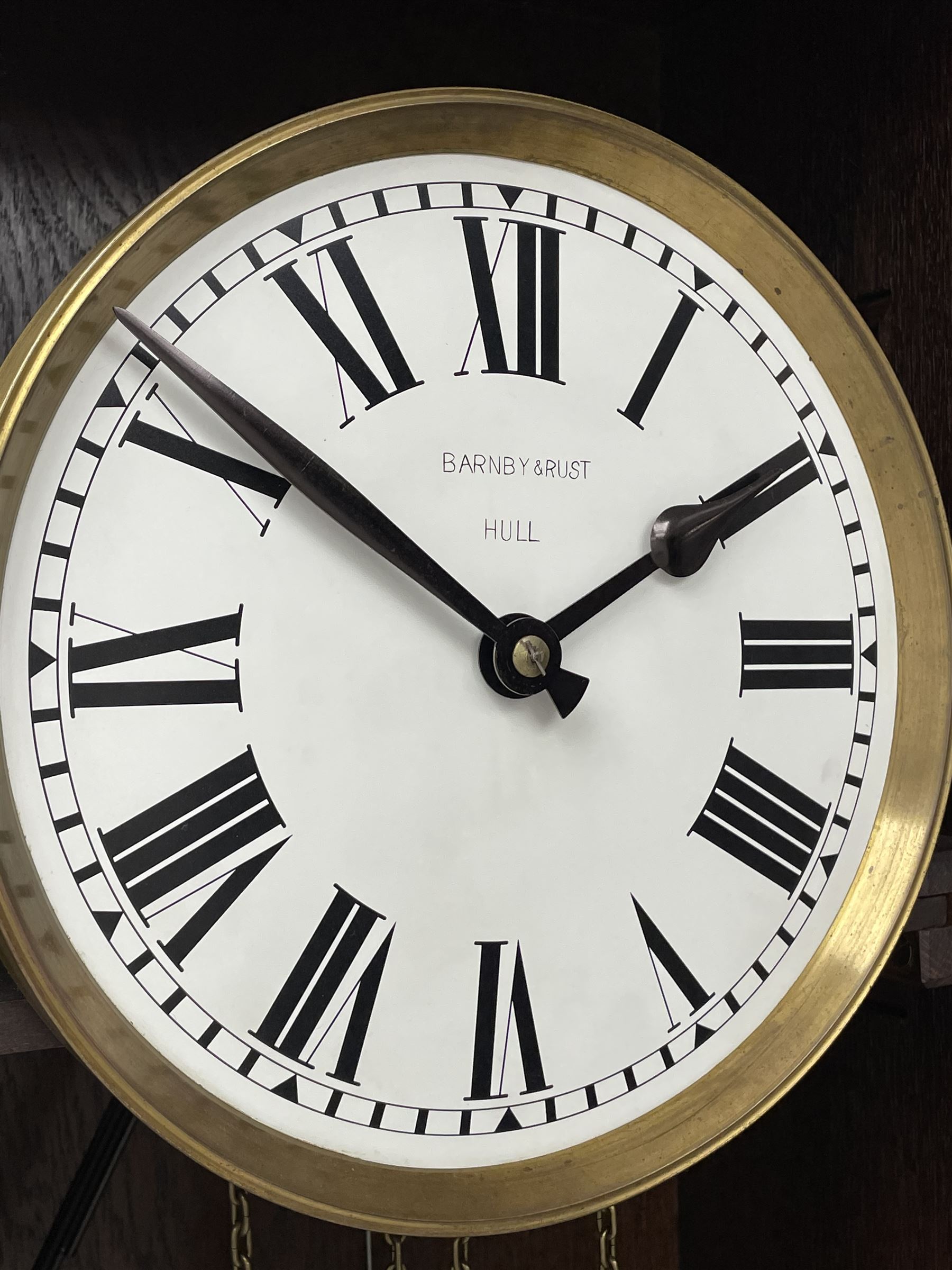 Early 20th century Art Deco oak longcase clock, circular dial with roman numerals and minute track, dial signed 'Barnby & Rust, Hull', twin chain driven movement striking the hours on gong rods. With weights and Pendulum.