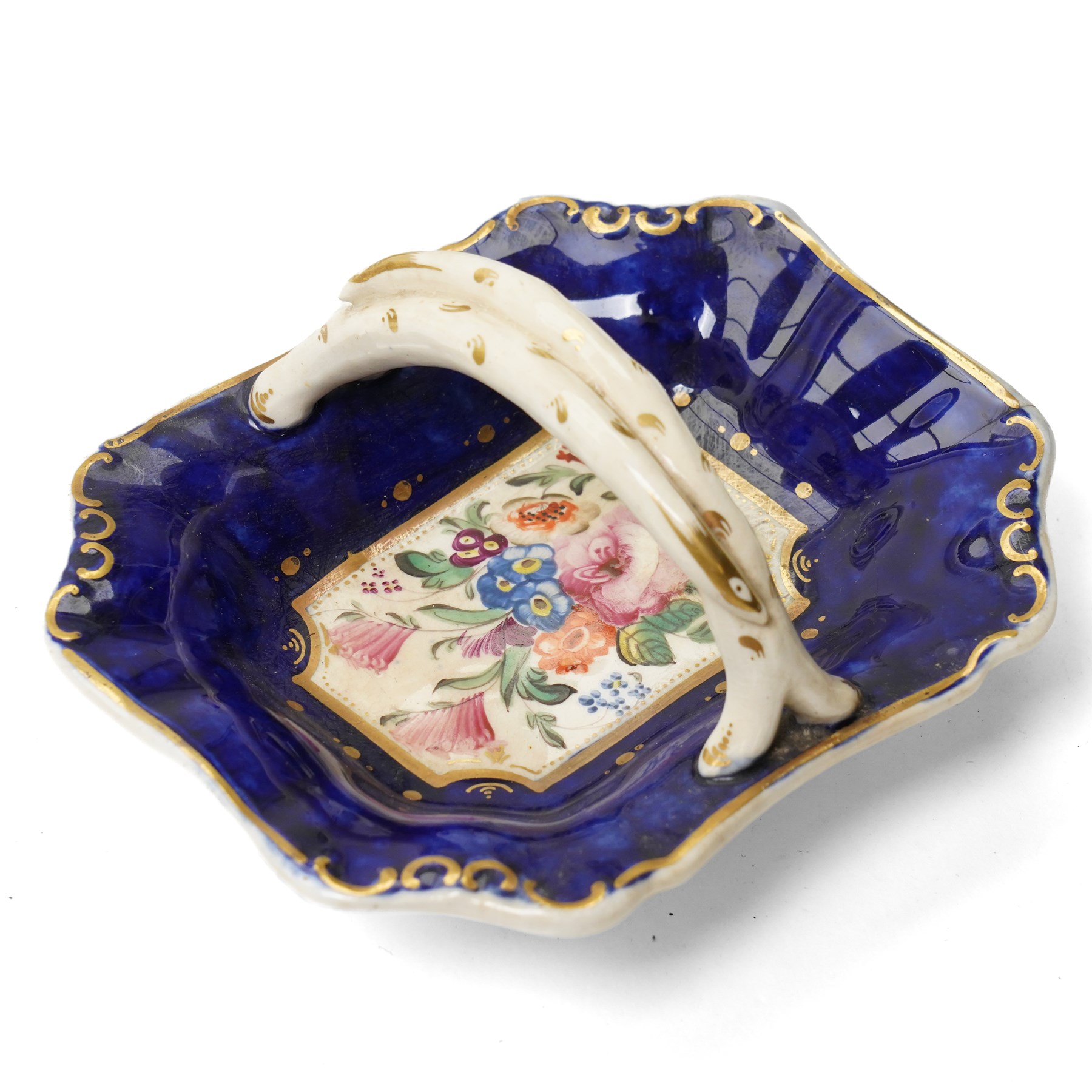 Collection of early 19th century Coalport pattern tea ware decorated with panels of flowers within a blue and gilt surround comprising eight tea cups, three coffee cups, eight saucers, four large plates, two handled sucrier and cover, milk jug and slop bowl and a similar small dish with loop handle