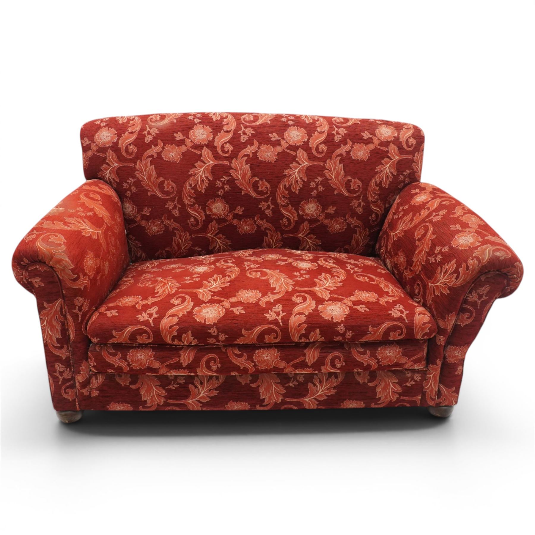 Edwardian hardwood framed petite two seat settee with single drop-arm, traditional shape with rolled arms, the drop-end with lever action adjustable height, the sprung back and seat upholstered in crimson foliate patterned fabric, on compressed bun feet