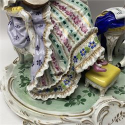 20th century Naples figure group, modelled as a seated female figure playing the lute seated, before a male figure stood holding a sheet of music, each in period dress, upon an oval base with gilt heightened scroll edge, with crowned N mark beneath, H31.5cm L33cm
