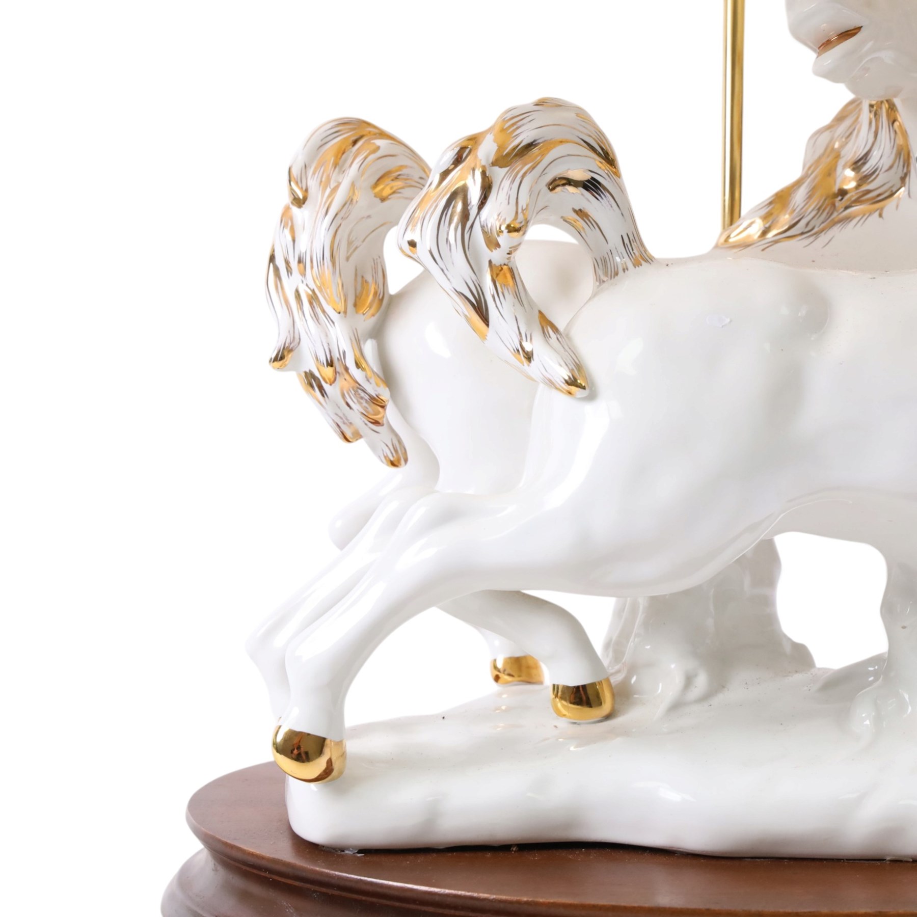 Italian-style ceramic table-lamp featuring two white running horses with gold accents, with cream tasselled lampshade, upon a wooden base, approx. H60cm W40cm