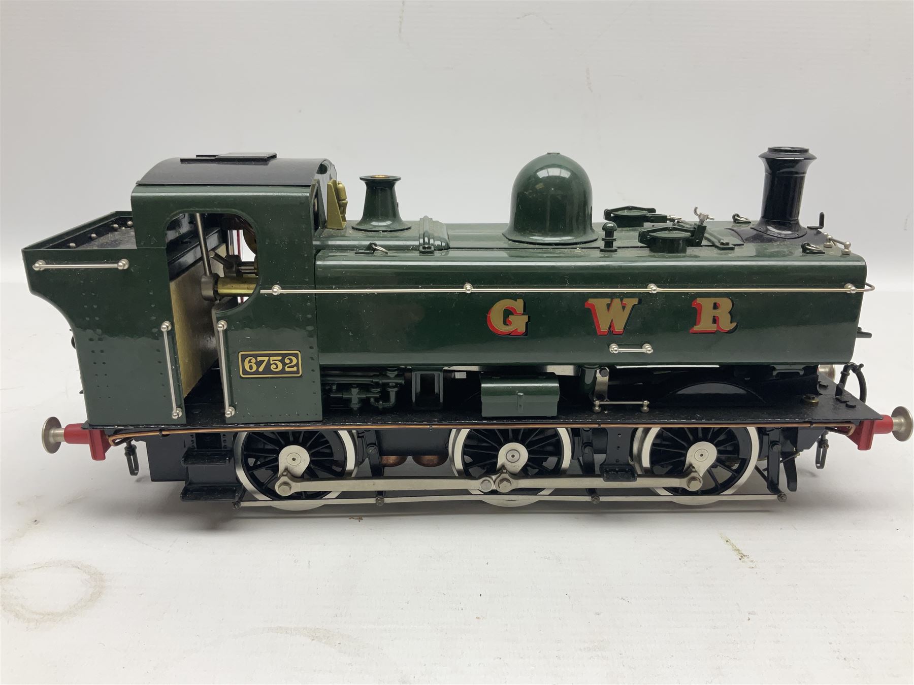 Gauge 1 - Aster 0-6-0 Great Western Railway Pannier tank locomotive No.6752; spirit fired and live steam powered with fitted steam pressure gauge, water sight glass and other usual fittings; finished in Great Western Railway green livery with GWR initials to the pannier tanks, fitted steps, handrails, checker plate, lamp irons, buffers and vacuum hoses; L31cm W8.5cm