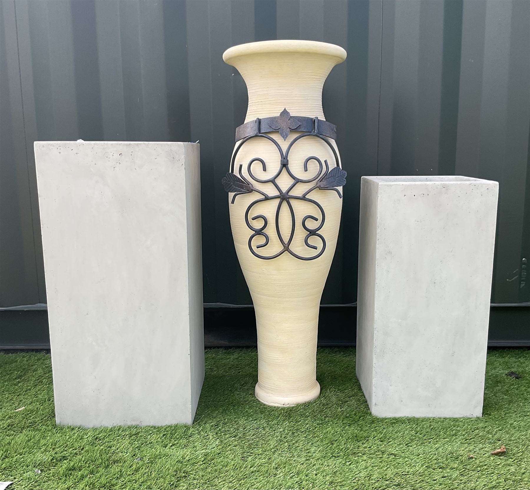 Graduating pair concrete effect square planters (largest - 34cm x 34cm, H71cm), and a tall garden urn planter with scrolled metalwork mount (H93cm) - THIS LOT IS TO BE COLLECTED BY APPOINTMENT FROM DUGGLEBY STORAGE, GREAT HILL, EASTFIELD, SCARBOROUGH, YO11 3TX