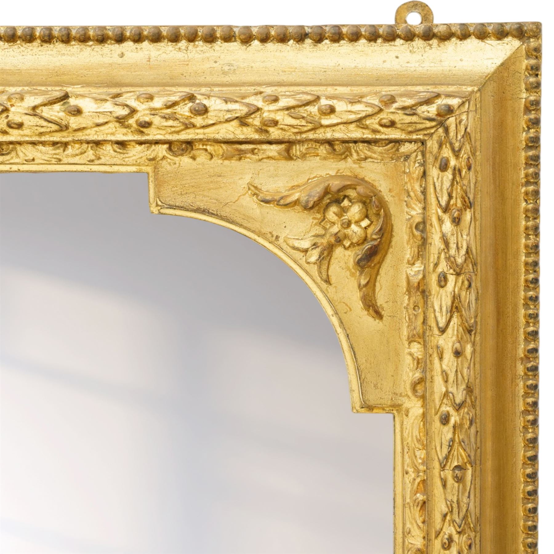 Victorian giltwood and gesso framed overmantel mirror, the scallop shell pediment with trailing acanthus leaves over a foliate moulded slip with beaded outer-edge, of rectangular arced form with floral spandrels, the base with further extending pierced scrolling acanthi decoration