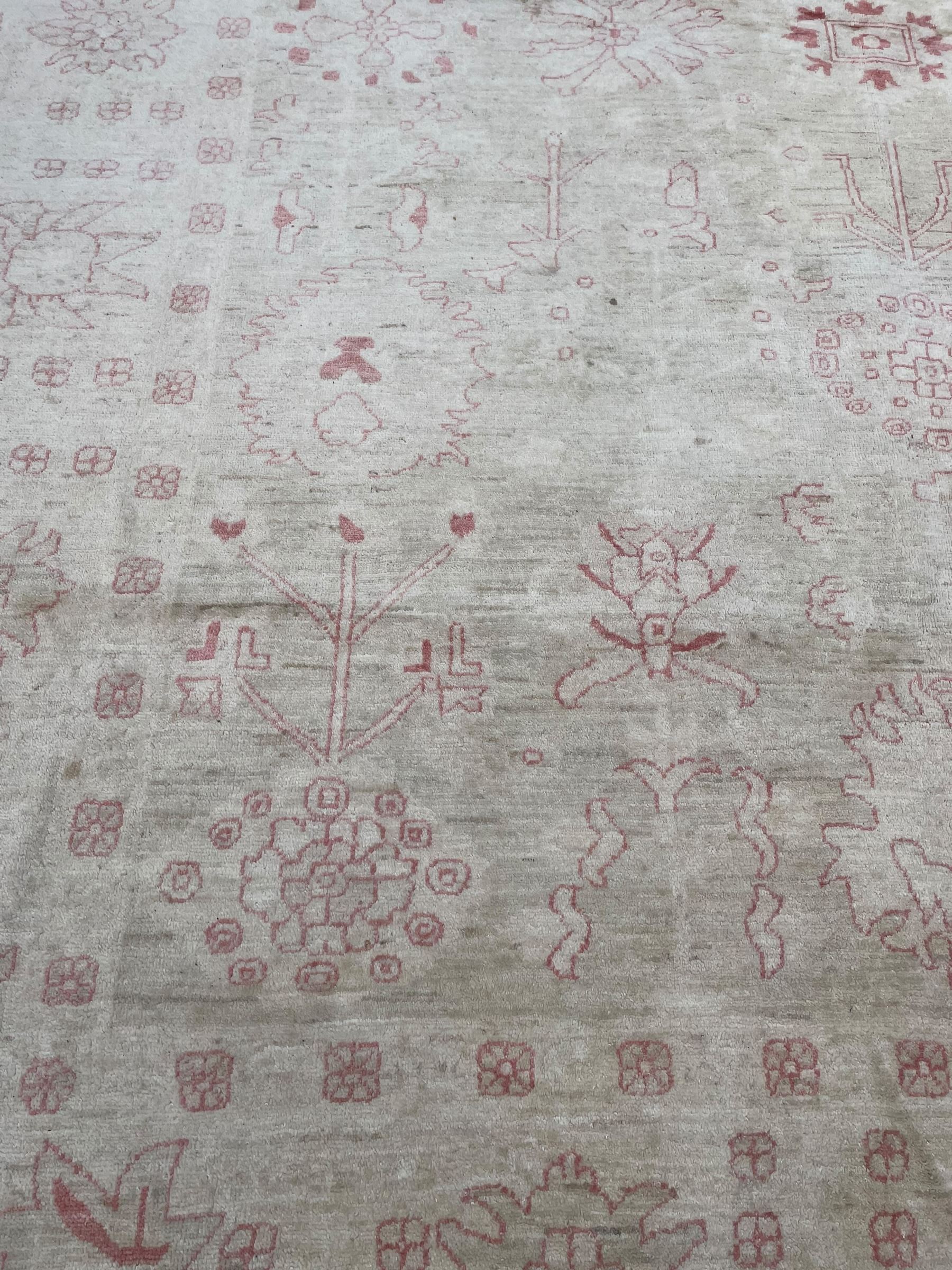 Persian design pale ivory ground carpet, decorated with stylised plant and leaf motifs in pale red