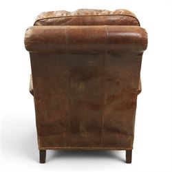 Art Deco style brown leather reclining armchair, scrolled arms with brass studded trim, reclining foot rest and back, fixed back and loose seat cushion,