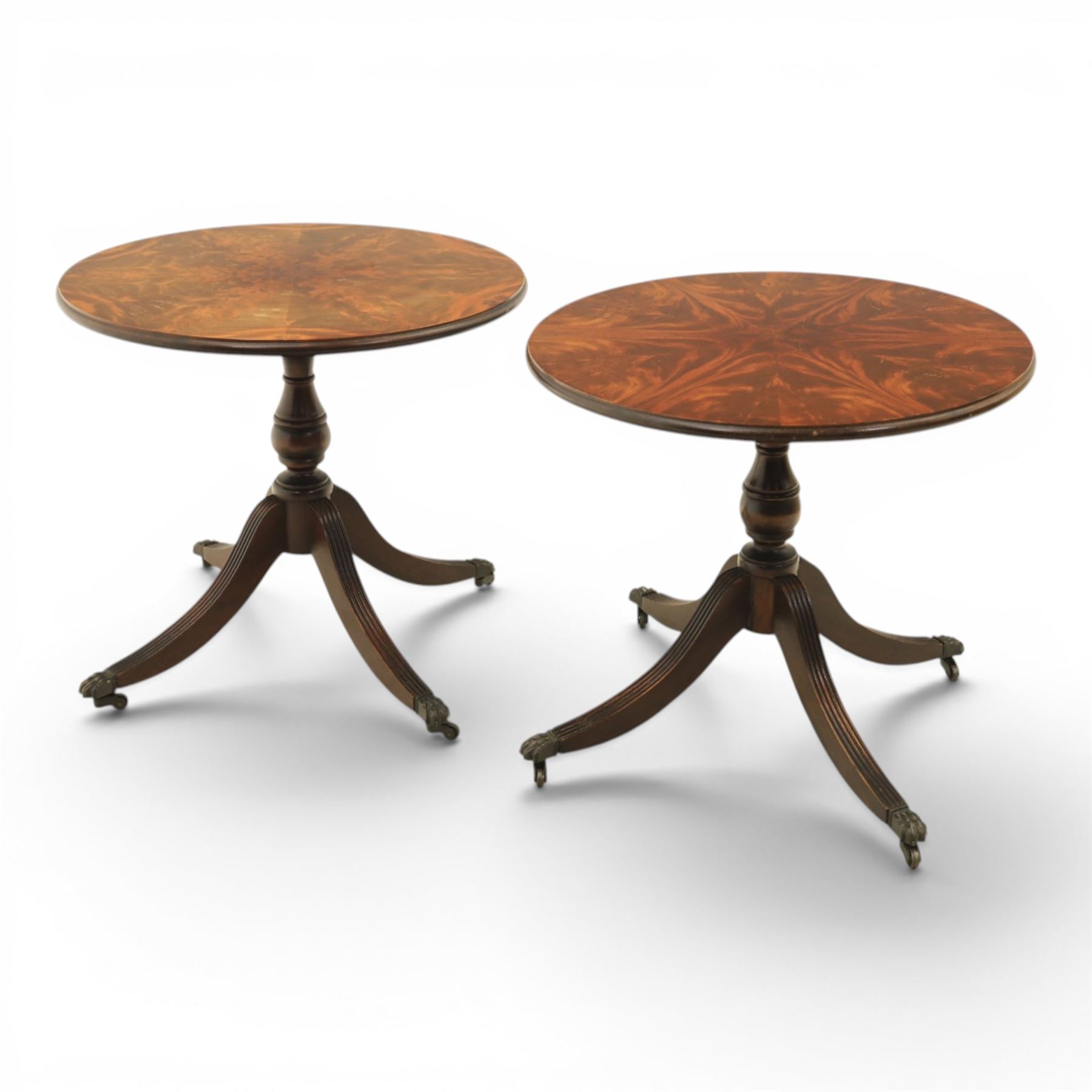 Pair of Georgian design flame mahogany wine tables, circular book-matched veneered tops with moulded edges, on turned pedestals and four reeded downswept supports terminating in brass caps and castors