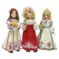Anna Meszaros Hungary - three hand made needlework figurines, each as a young girl in regional costume holding a bouquet of flowers H30cm (3)  Auctioneer's Note: Anna Meszaros came to England from her native Hungary in 1959 to marry an English businessman she met while demonstrating her art at the 1958 Brussels Exhibition. Shortly before she left for England she was awarded the title of Folk Artist Master by the Hungarian Government. Anna was a gifted painter of mainly portraits and sculptress before starting to make her figurines which are completely hand made and unique, each with a character and expression of its own. The hands, feet and face are sculptured by layering the material and pulling the features into place with needle and thread. She died in Hull in 1998.