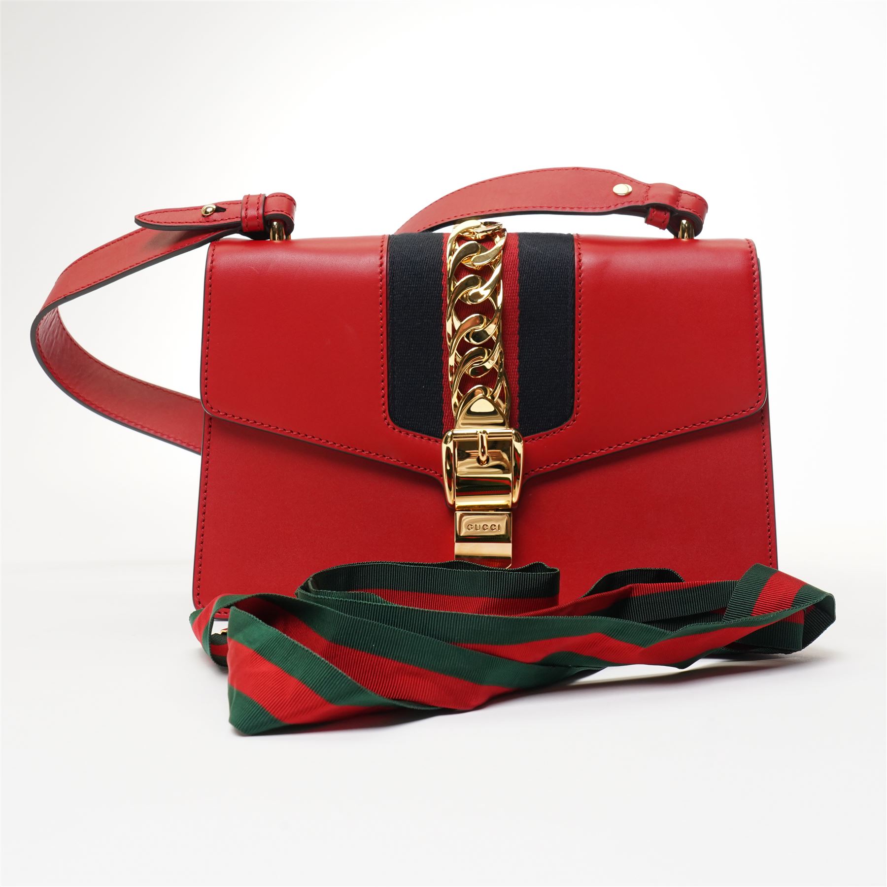 Gucci - ‘Sylvie’ Small Shoulder Bag, introduced circa 2016 under Alessandro Michele, in red calfskin leather with signature web stripe, gold-tone chain and buckle fastening and hardware, flat leather shoulder strap with alternative web-stripe grosgrain strap, unused with original dust bag