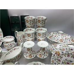 Minton Haddon Hall pattern tea and dinner wares, including basket dish, two covered tureens, six dinner plates, eight dessert plates, twelve tea plates, six soup bowls, six cereal bowls, teapot, coffee pot, milk jug, covered sucrier twelve tea cups and saucers, six mugs, footed bon bon dish, pair of candlestick holders, cake knife and slice etc (81)