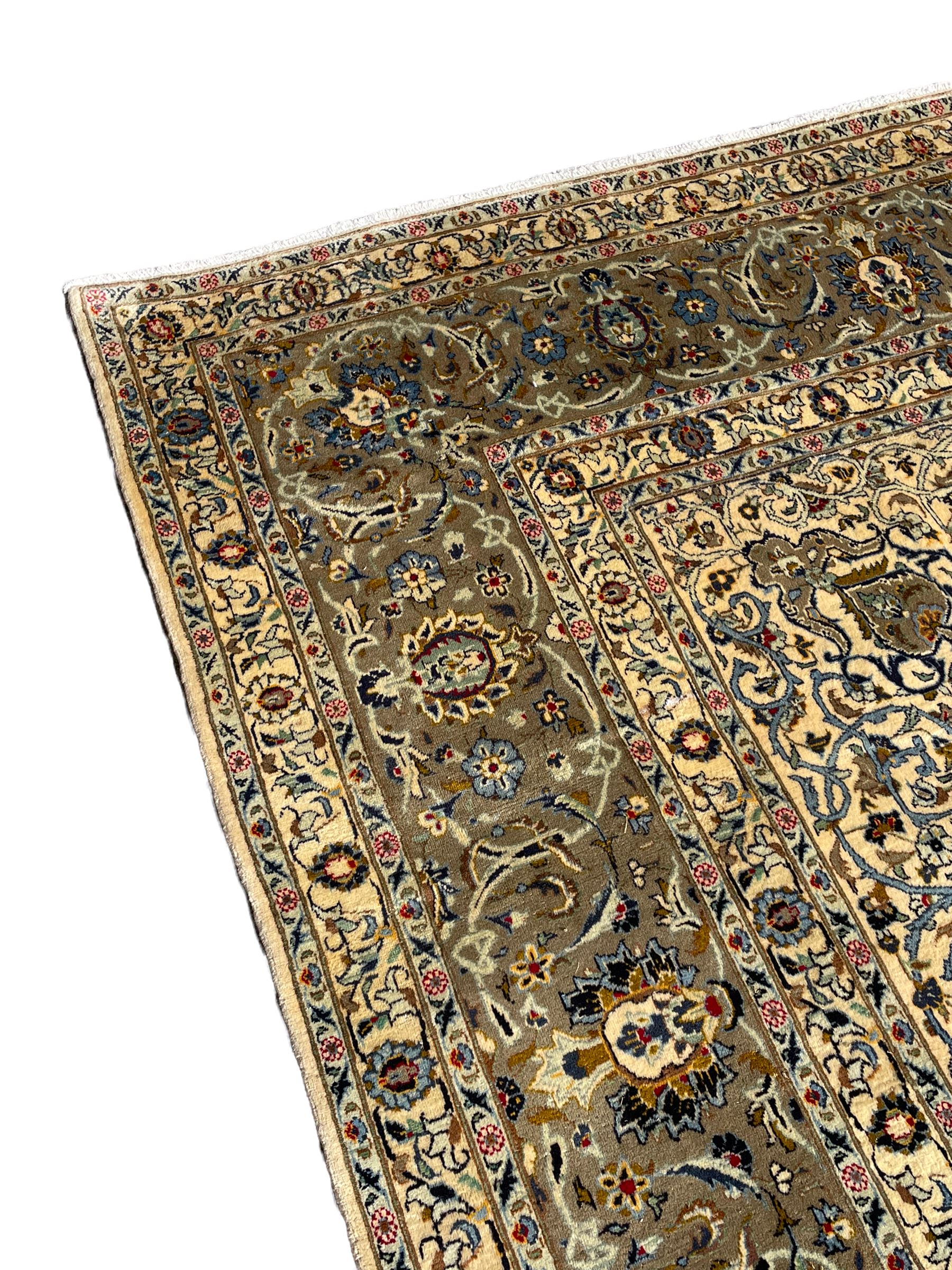 Persian Meshed carpet, ivory ground and decorated with intricate floral design with trailing scrolled branch, the central medallion decorated with stylised plant motifs, seven band border, the main band decorated with scrolls and flower head motifs