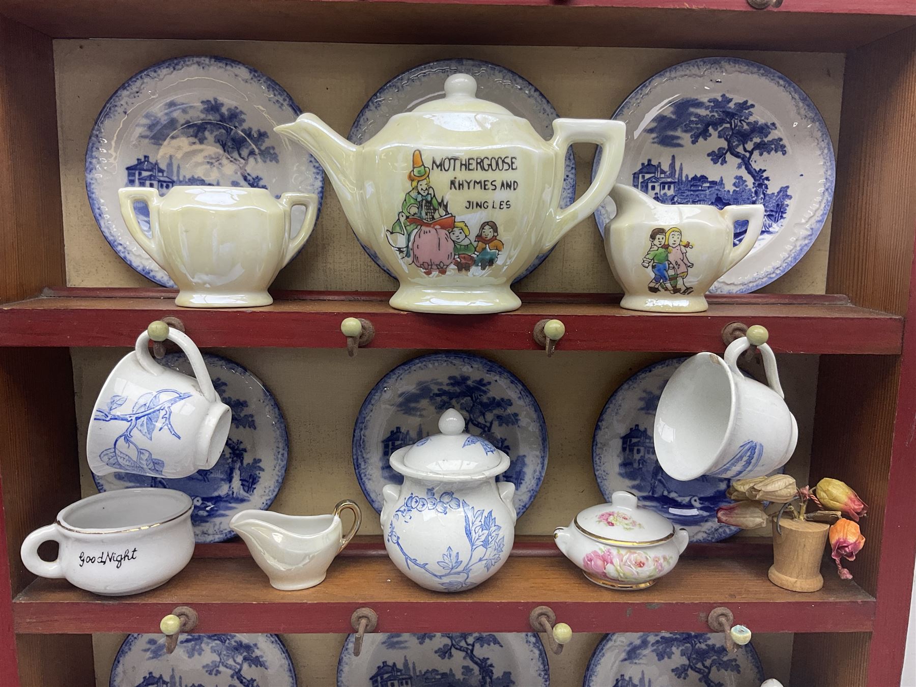 Miniature pitch pine Welsh dresser with open plate rack over two cupboard doors, displayed with Ridgways Humphrey's Clock pattern and other doll's blue/white tea ware, copper kettles and pan etc W41cm H72cm