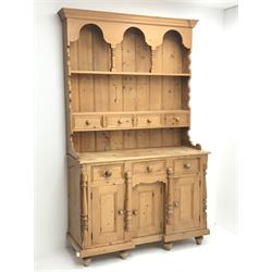 Solid waxed pine dresser, raised two heights plate rack with small drawers, the base fitted with three drawers and three cupboards, W127cm, H206cm, D47cm