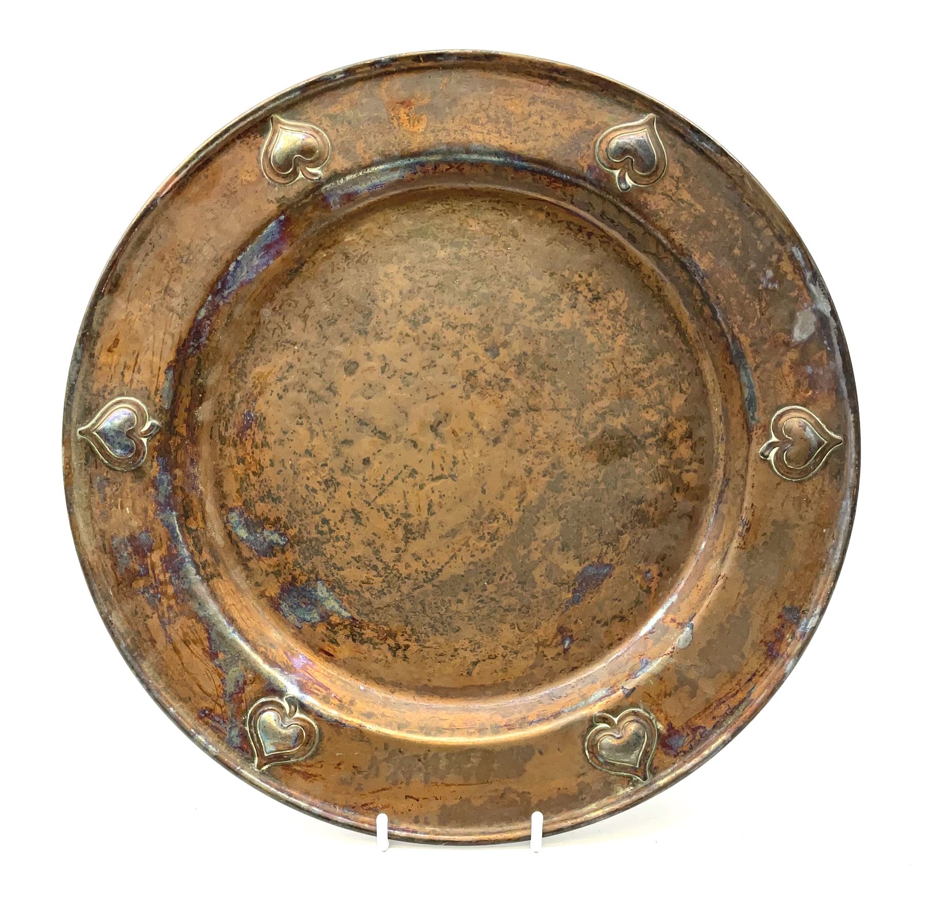 An early 20th century WMF Art Nouveau style copper plate, decorated to the rim with heart shaped motifs, with ostrich mark beneath, D30cm. 