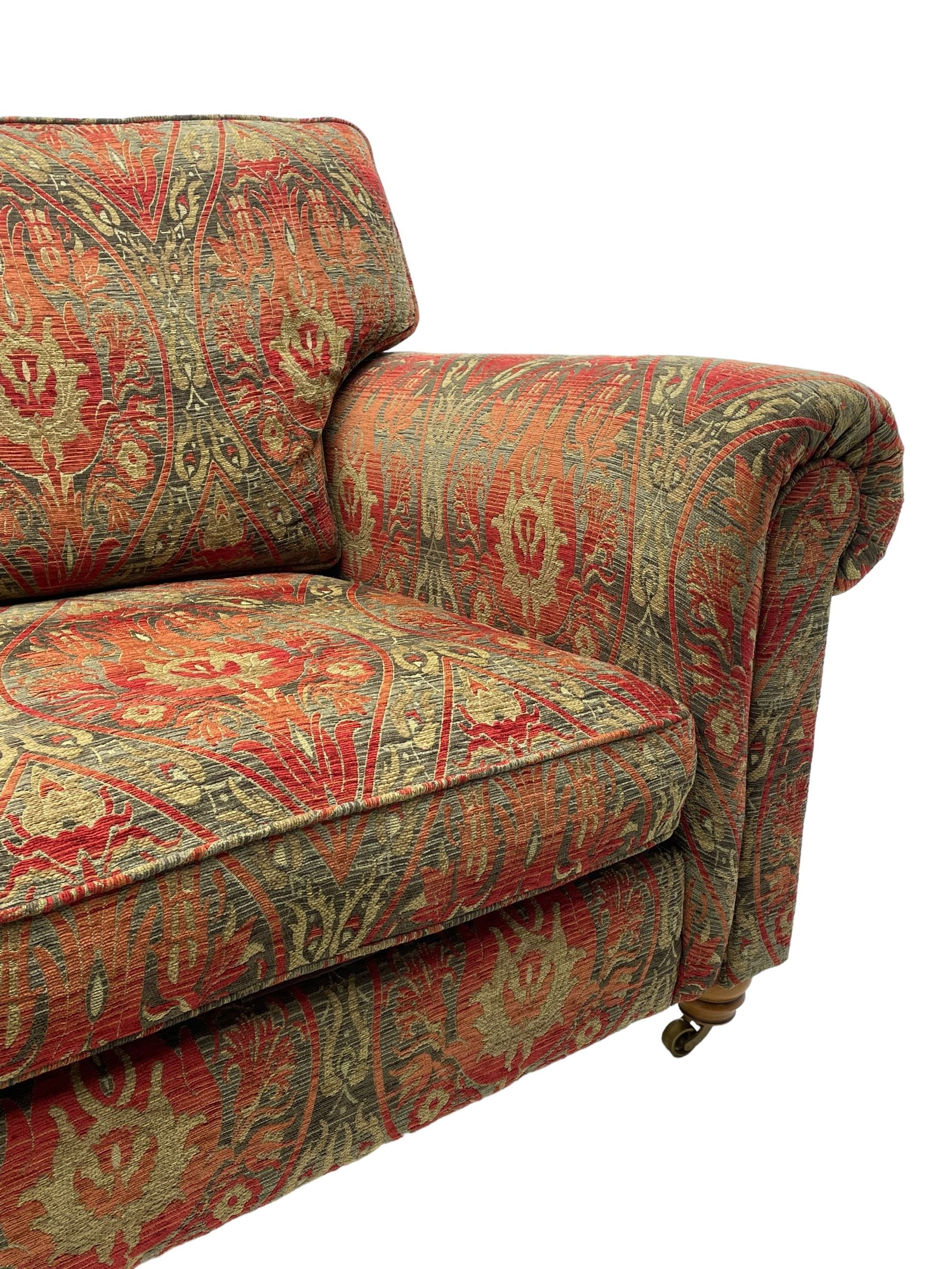 Duresta - 'Beaminster' grande two-seat sofa, traditional shape with rolled arms, upholstered in 'Althorp' russet and stone floral pattern fabric, on turned feet with brass castors
