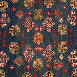 North East Persian Turkoman hand-knotted rug, deep teal blue field decorated with repeating rows of stylized octagonal guls and cruciform tribal motifs arranged in a lattice formation, enclosed composition featuring angular devices and reciprocal motifs, with cotton fringe ends
