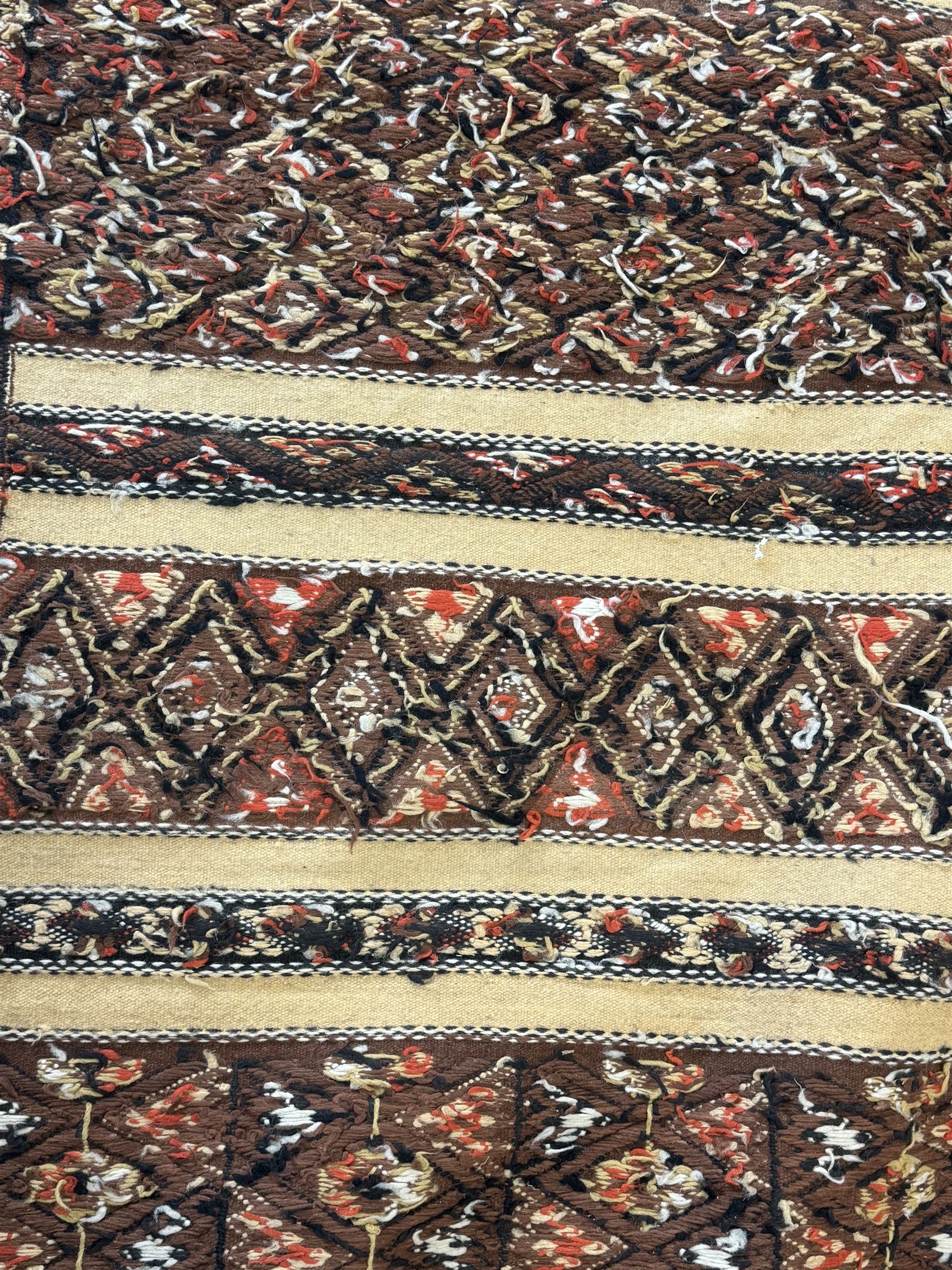 Turkish Kilim ground rug, the field with alternating horizontal bands of geometric patterns, bordered by repeating diamond motifs (145cm x 242cm); Turkish red ground rug, the field with three octagonal medallions (113cm x 172cm) (2)