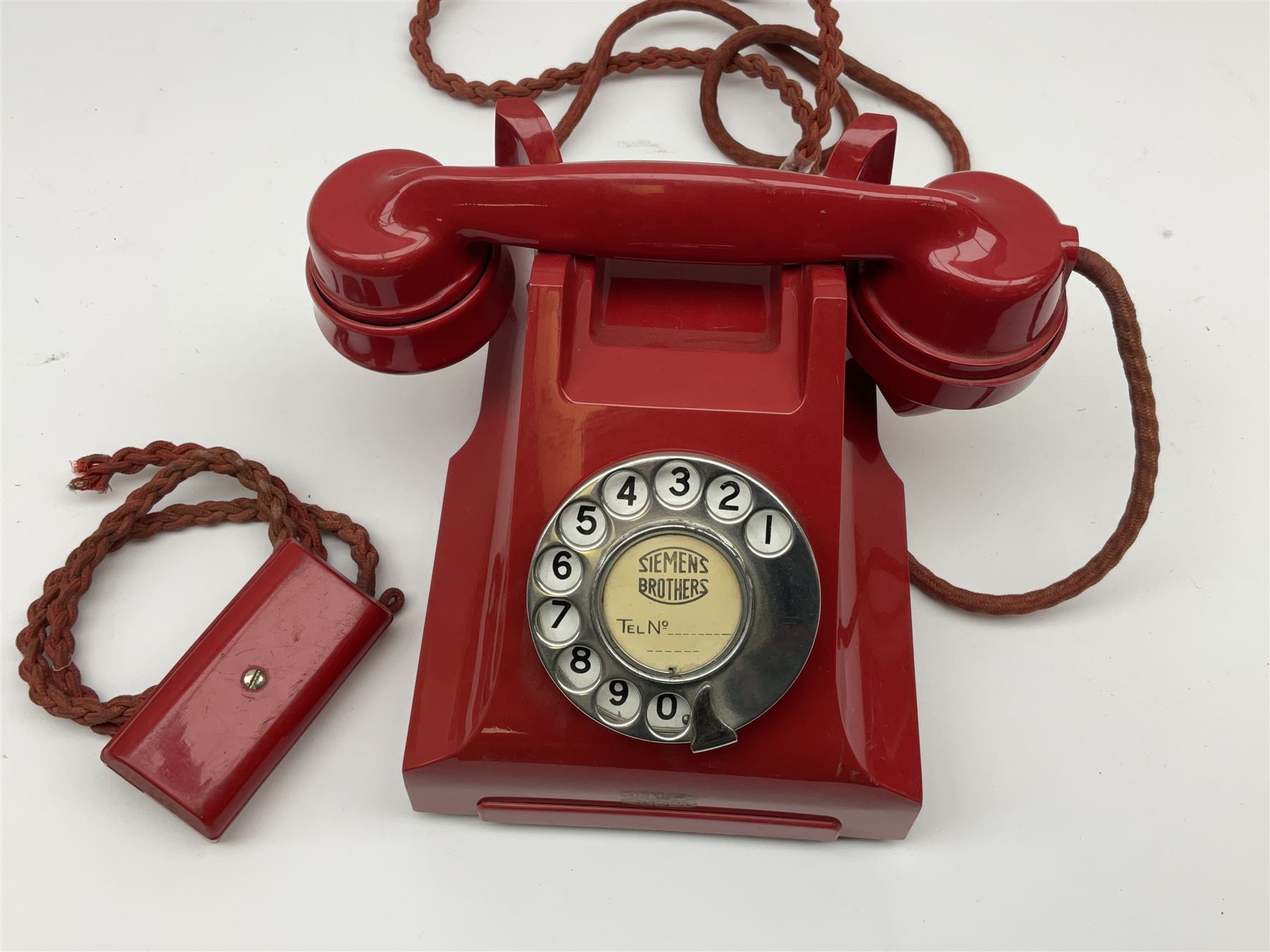 1950s Siemens Brothers red telephone with chrome rotary dial with enamel number plate and Siemens dial label, model 356, the body with base drawer below gilt logo, the handset with impressed mark PAT. 328926 PAT. SA 9/30, with red braided cord and red junction box (detatched), W15cm D18.5cm H14cm