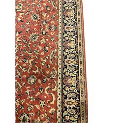 Persian design red ground carpet, the field decorated with interlacing foliage and stylised flower heads, repeating scrolling boarder with plant motifs