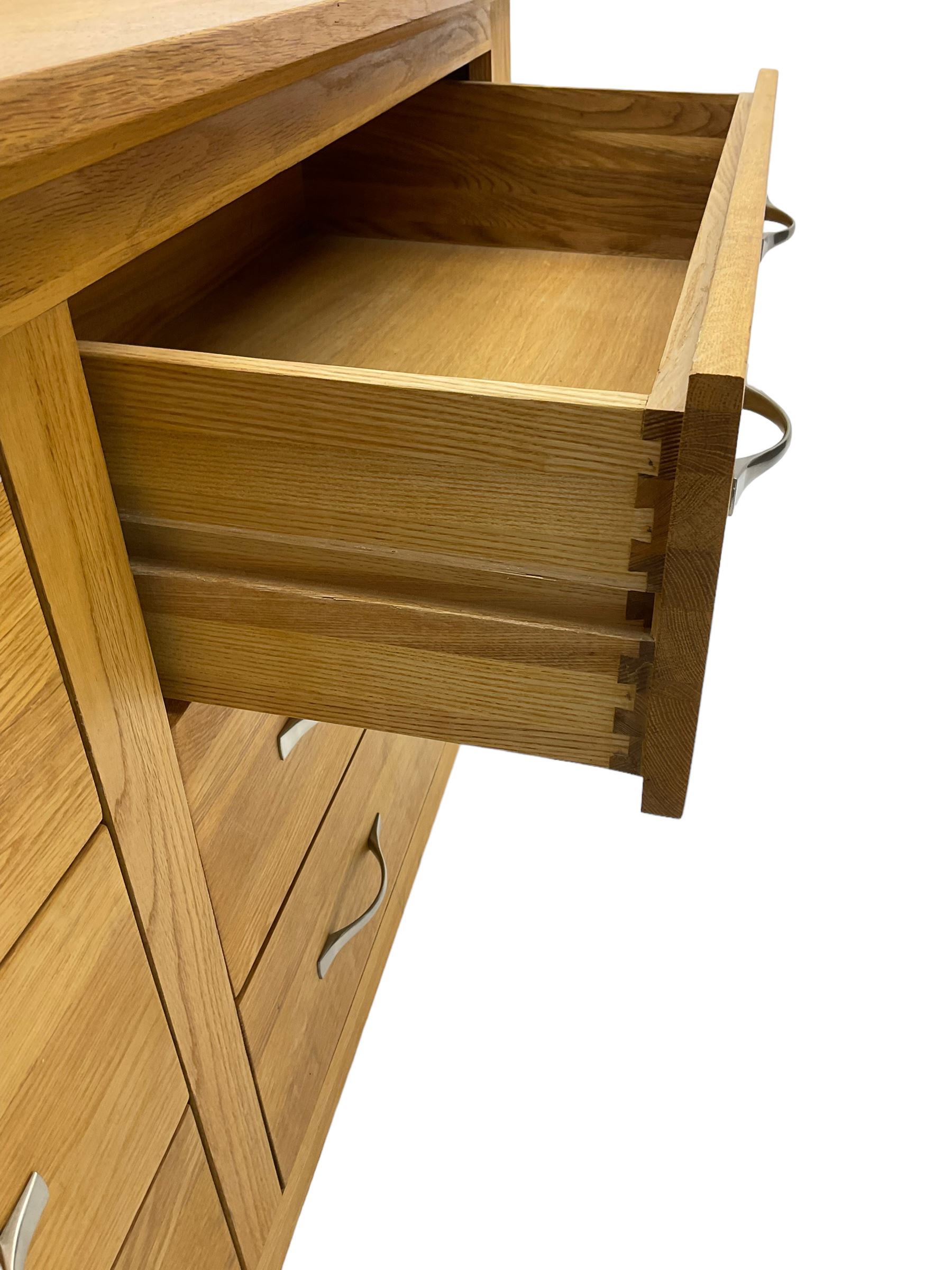 Contemporary wide oak straight-front chest, fitted with a bank of six drawers with chrome handles, on tapered feet