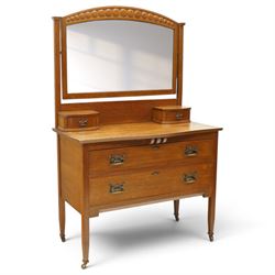 Manner of Liberty & Co. - Arts & Crafts oak dressing chest, the arched swing mirror with roundel-carved frieze and bevelled plate, serpentine-front top with two raised trinket drawers, fitted with two drawers with brass Art-Nouveau poppy handle-plates, on square tapering supports with castors