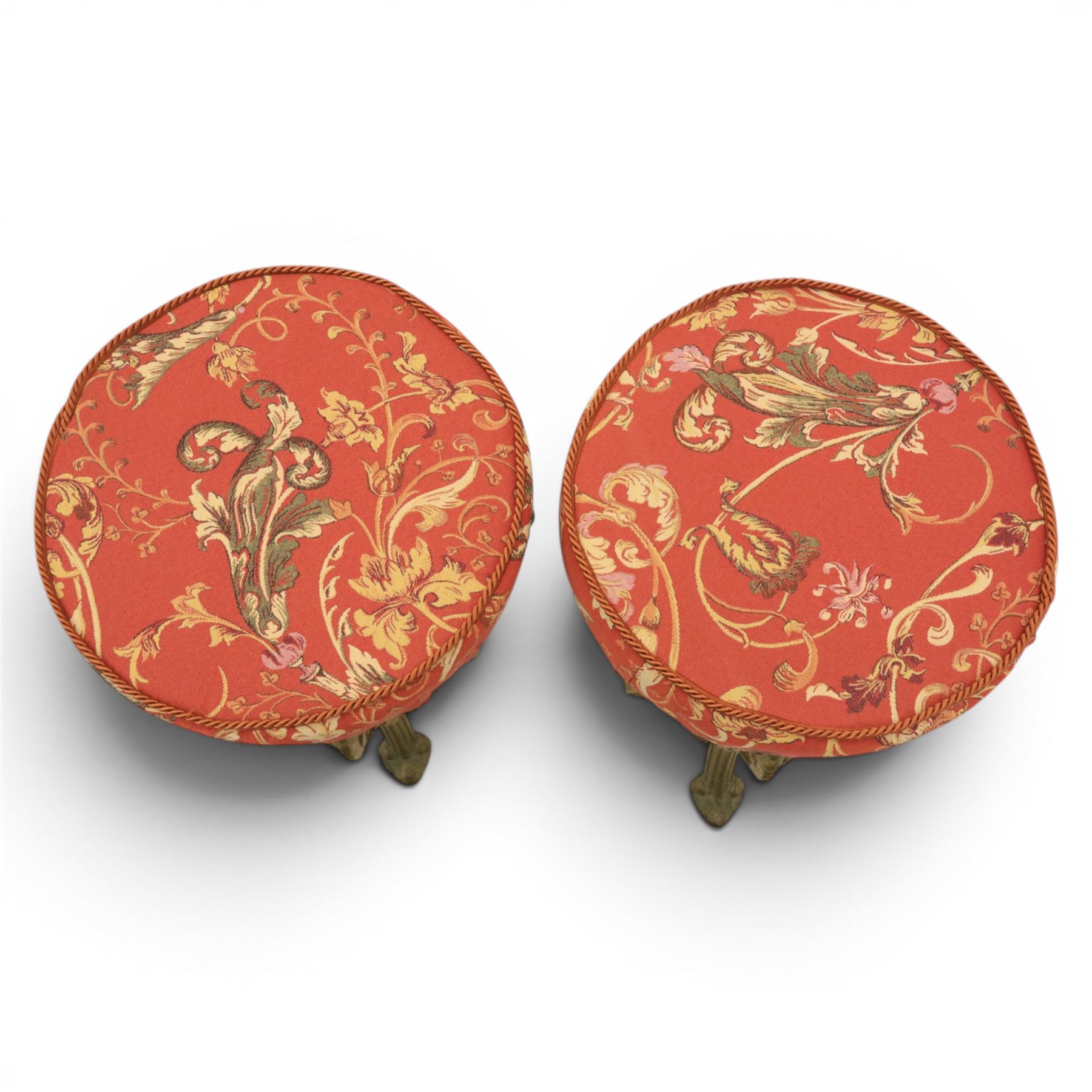 Britannia style cast iron pub table and pair of stools, moulded circular top raised on a gilt painted frame, featuring masks and acanthus detailing united by an under tier, the stools with red floral design (Stools diameter 34cm, height 47cm) 