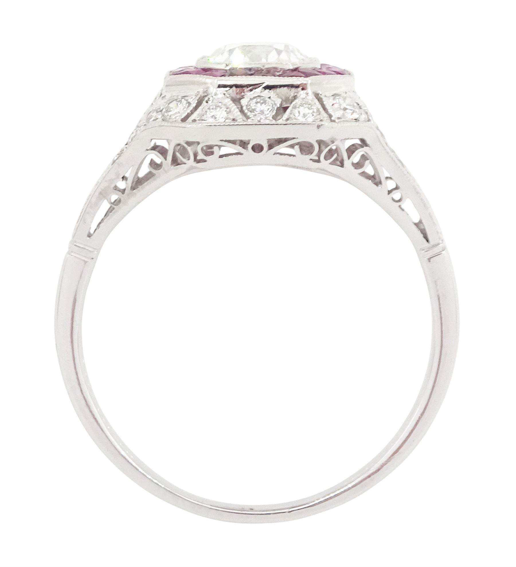 Platinum diamond and ruby cluster ring, the principal transitional cut diamond of approx 0.65 carat, in an octagonal milgrain setting, surrounded by calibre cut rubies, to further round brilliant cut diamonds and a split design shoulders