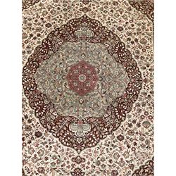 Persian design rug, ivory ground field decorated central shaped medallion surrounded by trailing foliate motifs, the border with floral design panels within multiple guard stripes 