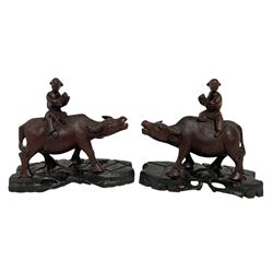 Pair of Chinese hardwood figures of farmers riding water buffalo, on stands, H19cm