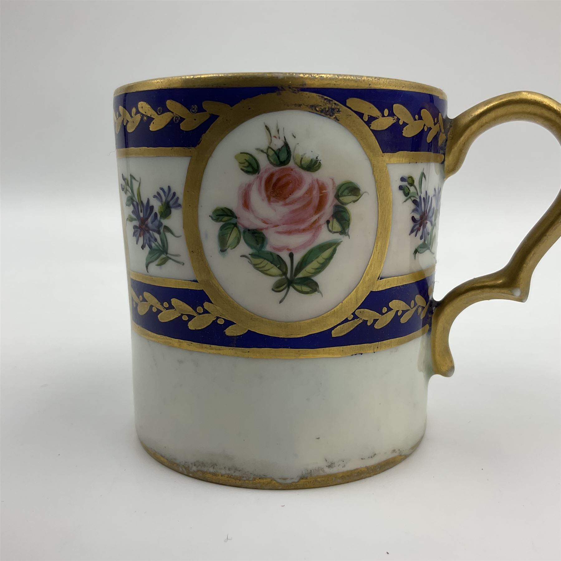 19th Sèvres style porcelain cup and saucer, the cup painted with a figural scene, against a scalloped border of scrolling floral swags on a blue ground, together with a Sèvres soft paste porcelain coffee can and saucer, painted with panels of exotic birds, roses and a border of cornflowers, LL monogram enclosing date letters H above painters mark, coffee can H6.5cm, saucer D13.5cm (2)